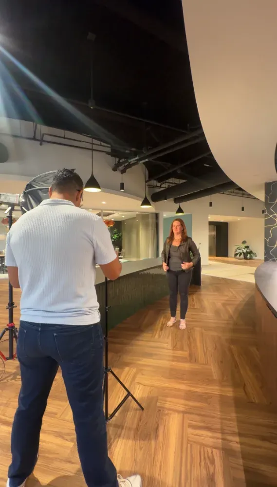 Our videographer filming a client in an office lobby